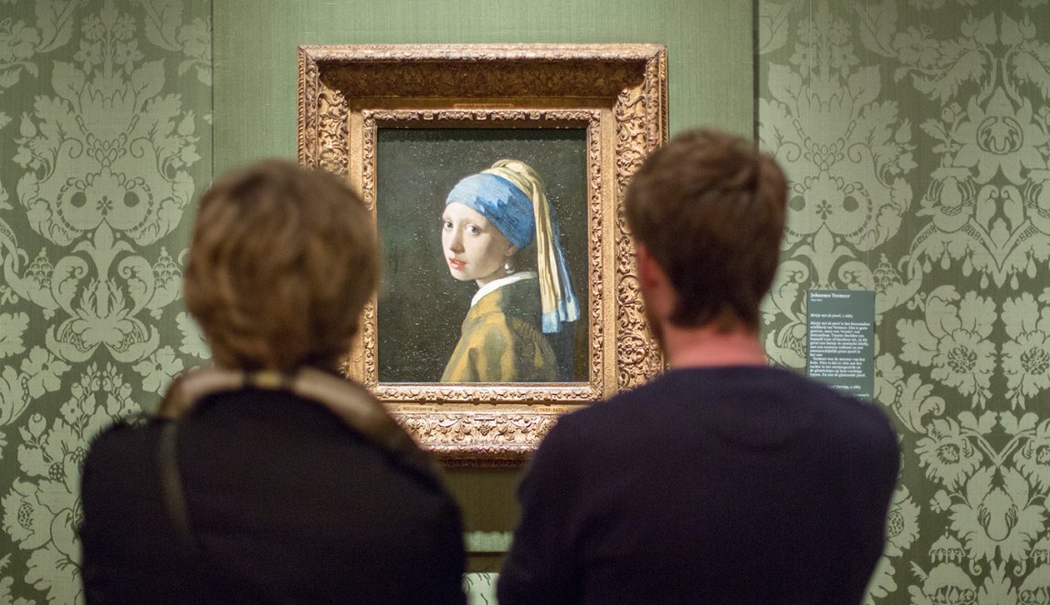 Visitors view painting Girl with a Pearl Earring part of the Mauritshuis collection 