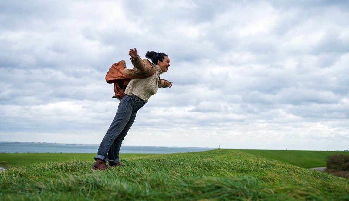 Woman hangs against strong headwinds in Zeeland