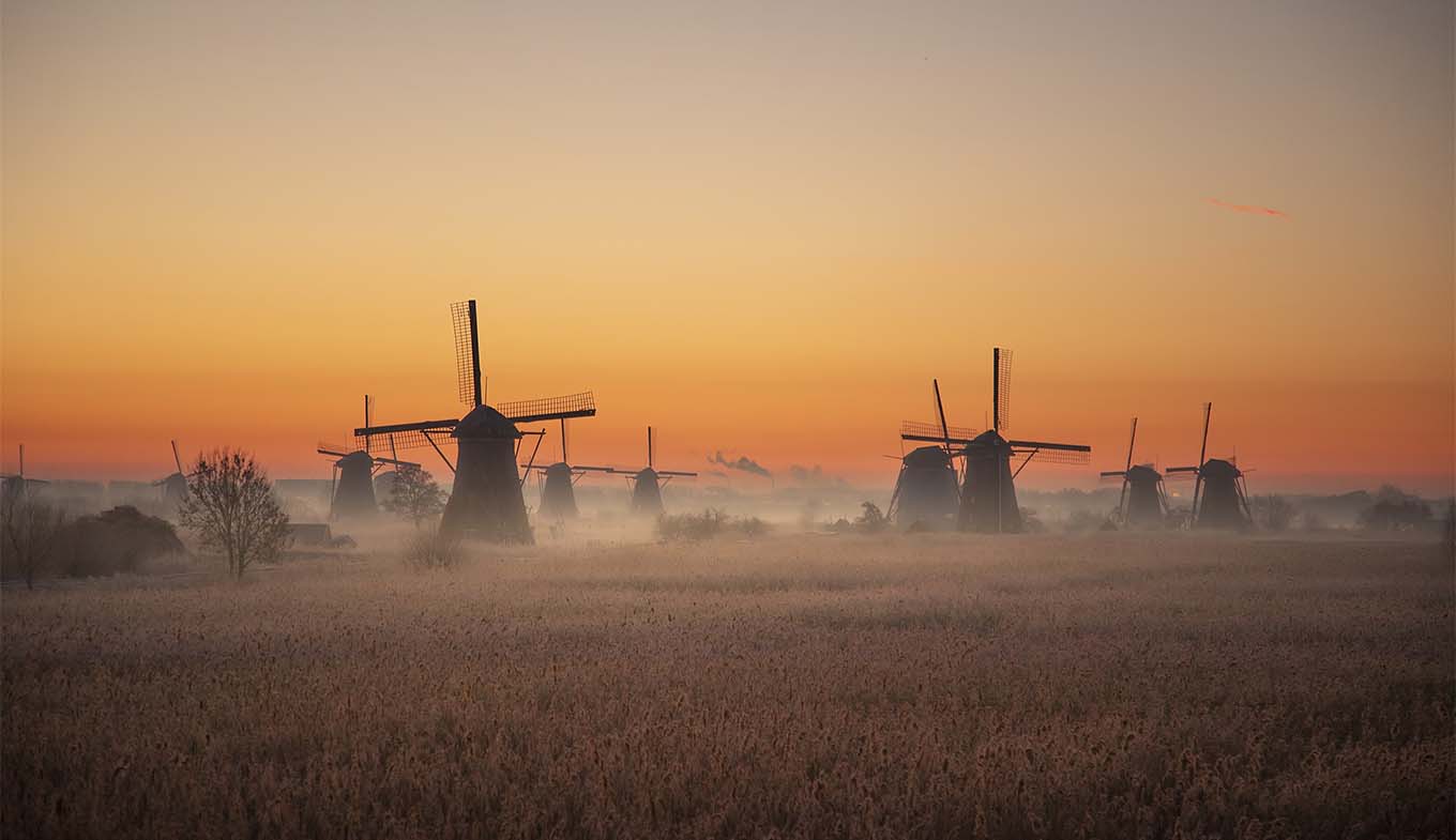 The windmills of Kinderdijk in the light of morning glory with a sunrise.