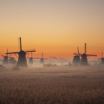 The windmills of Kinderdijk in the light of morning glory with a sunrise.