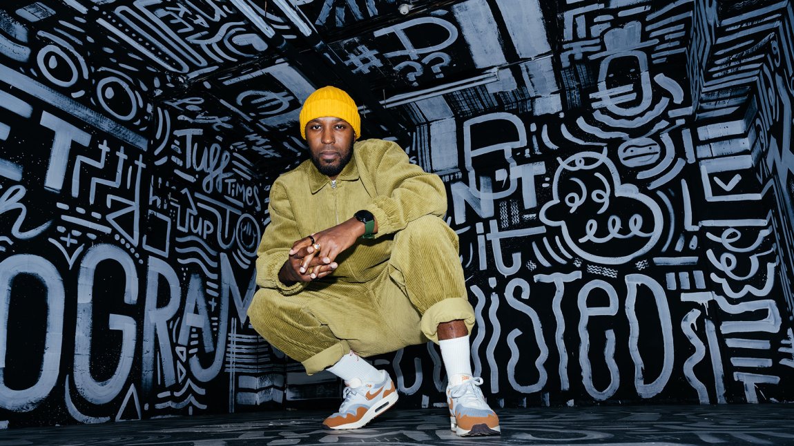 Portraitphoto Elten Kiene squatting on sneakers in front of black and white graffiti