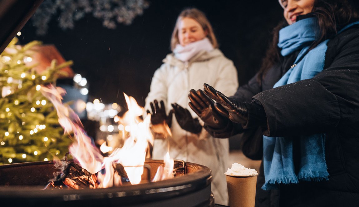 Warm hands by fire with hot chocolate