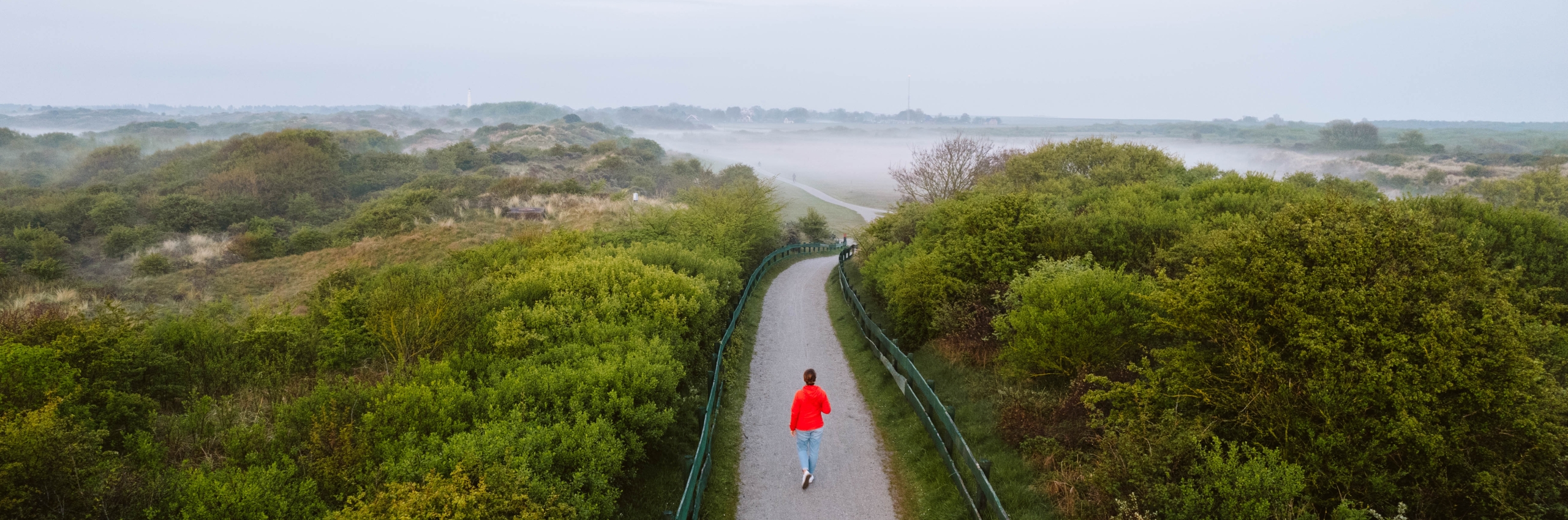 View of Schiermonnikoog with women in a red coat walking