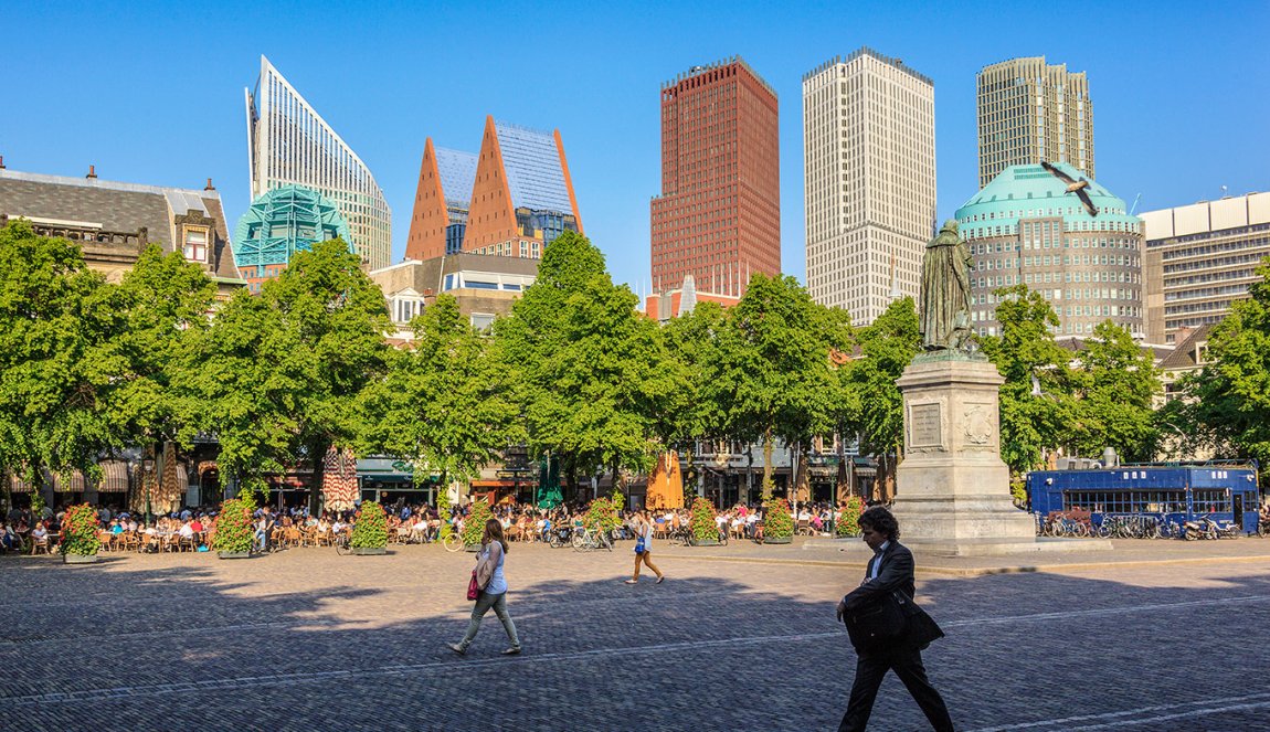 Strollers on the Plein with The Hague skyline in the background