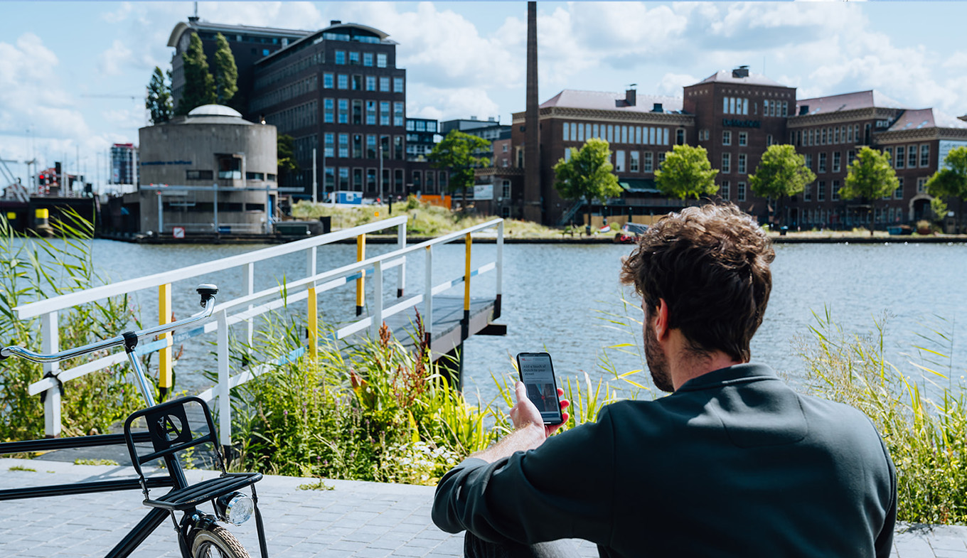 Lior Steinberg sitting by water with mobile phone