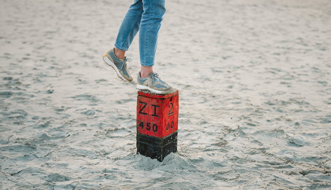 Lady foot on pole in sand on beach in Schiermonnikoog Friesland