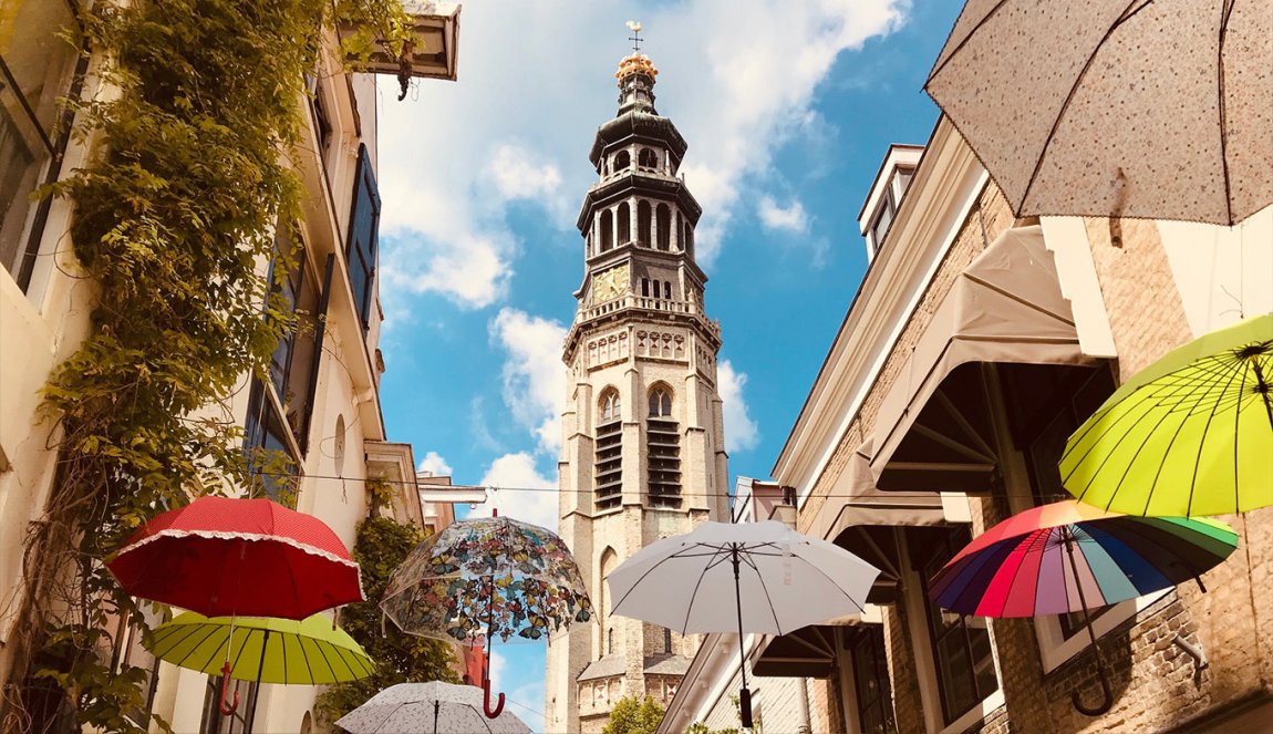 Heron Street during the day with hanging umbrellas and the tower 